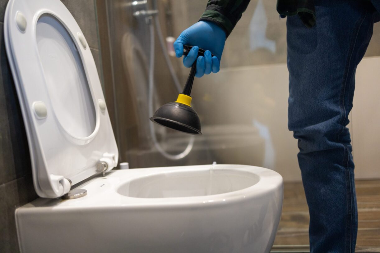 clogged toilet getting plunged by plumber